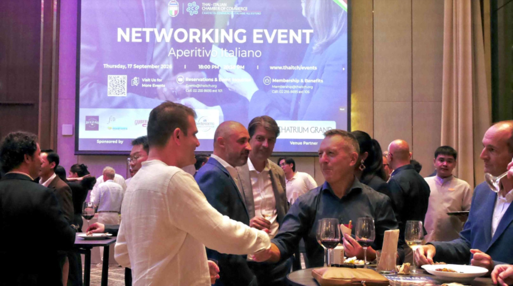 Guests standing in front of the networking event screen